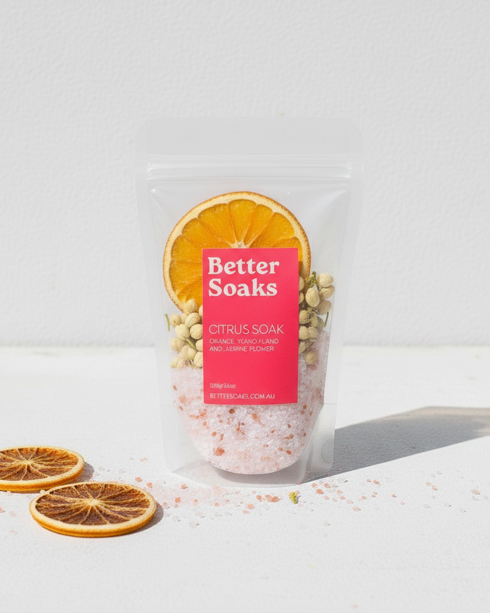 Packaged bath product with 'Better Soaks' label and orange slices on a white background